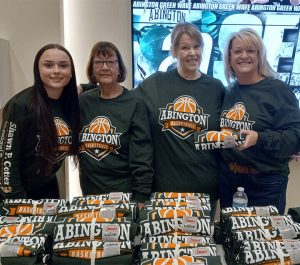 Abington Bank employees hand out t-shirts at the 2023 Shawn P. Cotter Memorial Basketball Tournament. From left to right: Lily Shea, Anne Costa, Stephanie Davis, and Christine Johnston.
